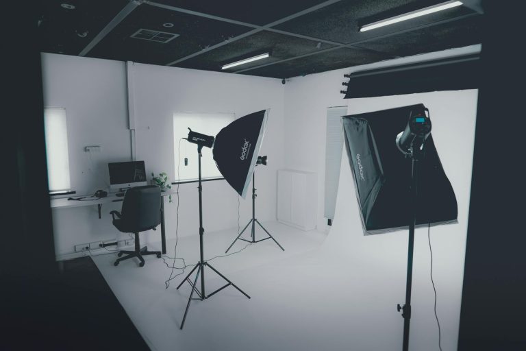 A modern photography studio with professional lighting equipment and a computer workstation.